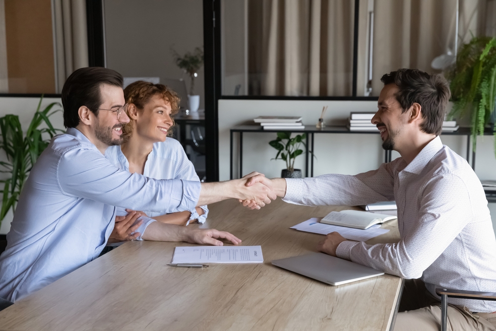 Confident,Lawyer,Meeting,And,Shaking,Hands,With,Happy,Couple,Of